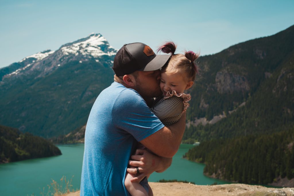 man wearing blue crew neck t shirt holding girl near