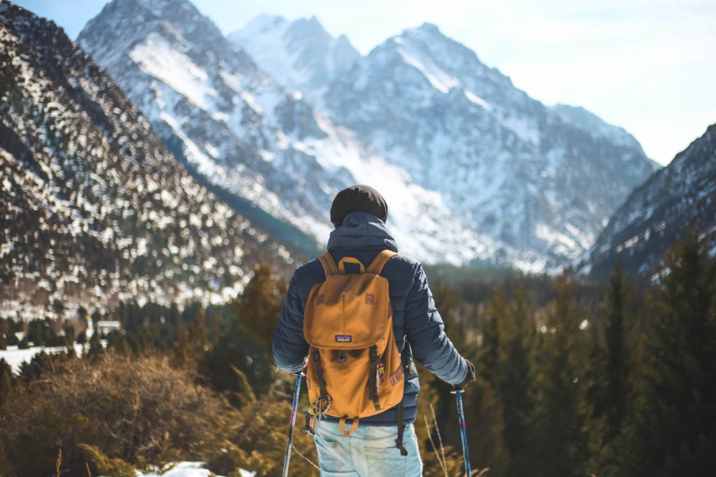 men s blue leather jacket and brown backpack