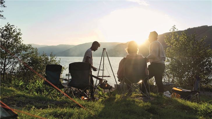 Easy Camp Camp Fire Tripod Deluxe group cooking at sunset